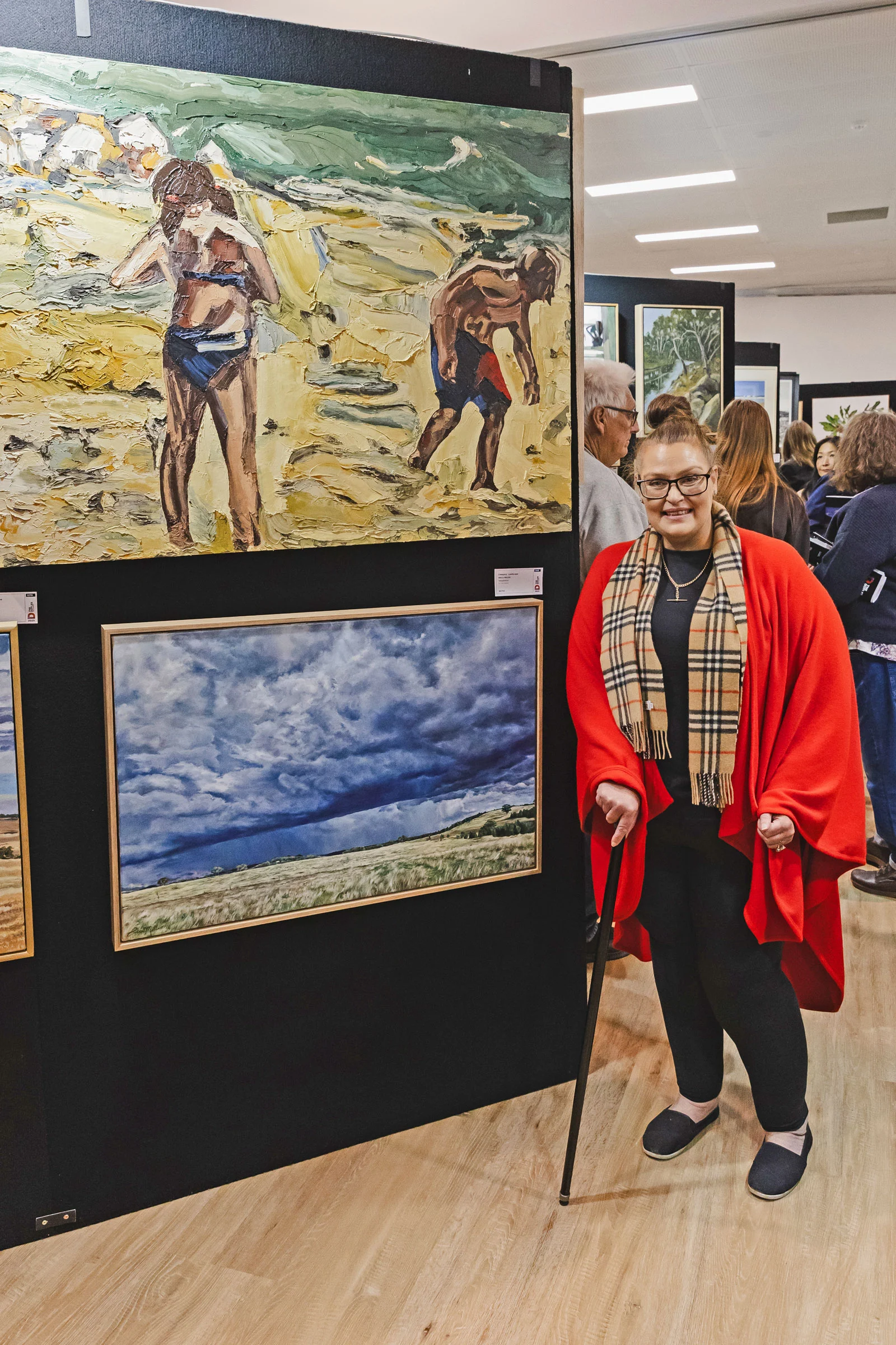 Jane Allan at the Doyles Art Award exhibition 2026 beside her winning painting Seaside Explorers